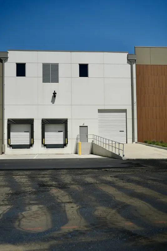 Freshly paved asphalt in front of warehouse loading docks