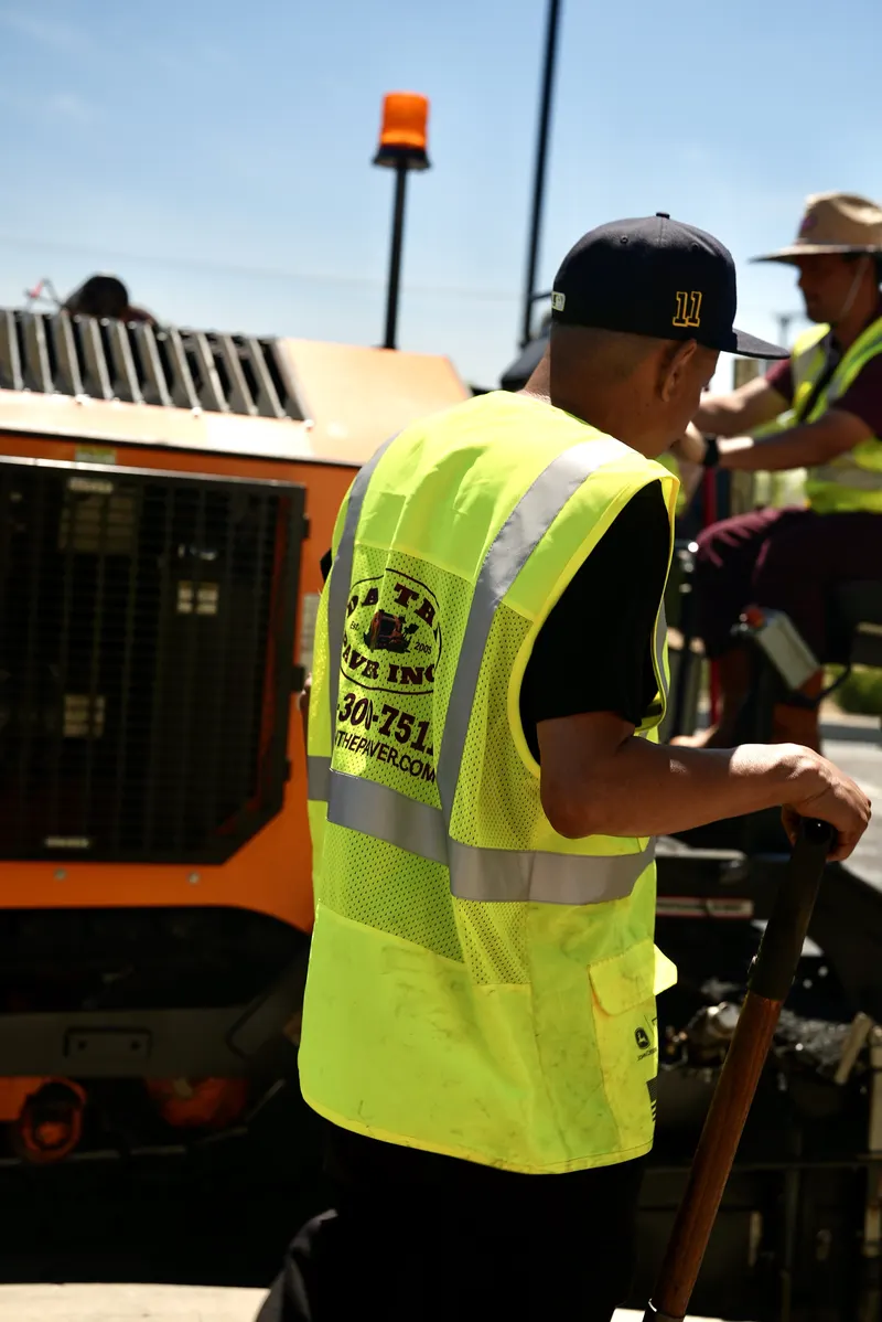 Dan The Paver crew working the paving machine controls on a commercial parking lot