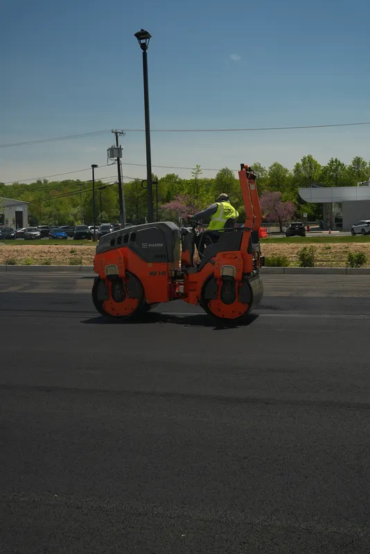 Roller making a pass over a new asphalt parking lot