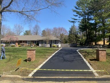 freshly paved asphalt driveway by Dan the Paver with white lines.